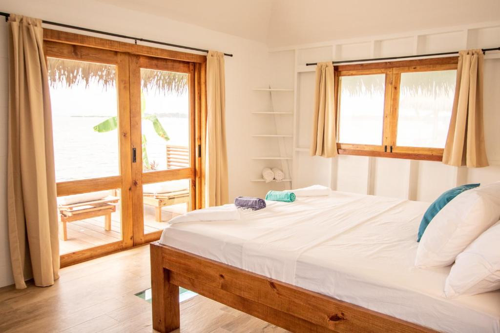 a bedroom with a bed and a large window at Sol Bungalows Bocas del Toro in Bocas del Toro