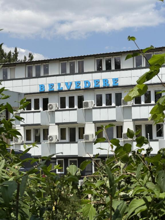 a white building with a blue sign on it at Belvedere Costinesti in Costinesti
