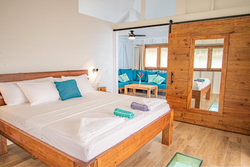 a bedroom with a large bed with blue pillows at Sol Bungalows Bocas del Toro in Bocas del Toro