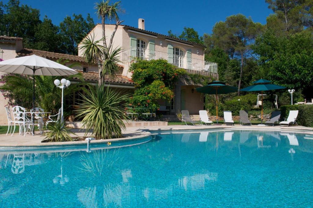 - une piscine avec des chaises et des parasols à côté d'une maison dans l'établissement Chambre d'hôtes le bois des combes chambre 