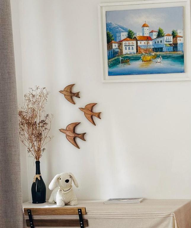 un ours en peluche assis sur une table avec des oiseaux sur le mur dans l'établissement Appartement Claudia - Central - Very close to Sea - Calm - AC, à Nice