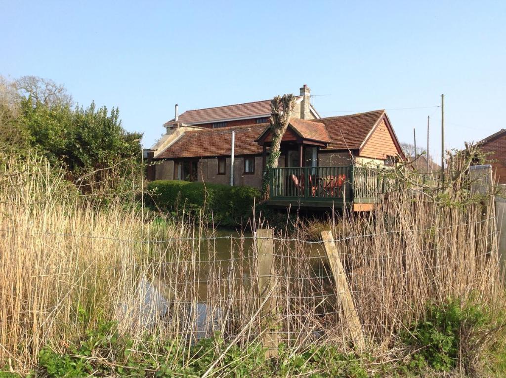 uma casa com uma cerca em frente em Stable Cottages em Cowes