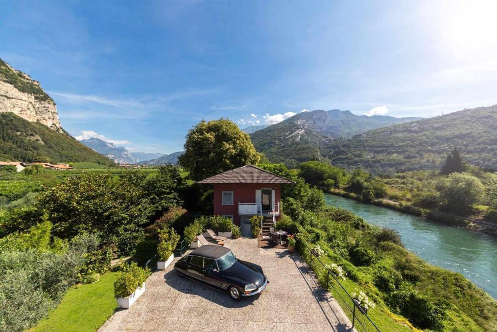 a car parked in front of a house next to a river at Torbole Holiday House in Nago-Torbole