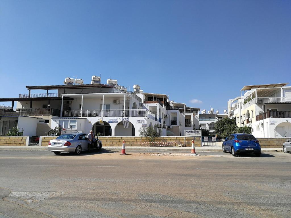 two cars parked in a parking lot in front of buildings at Apartment Sun Kapparis in Paralimni