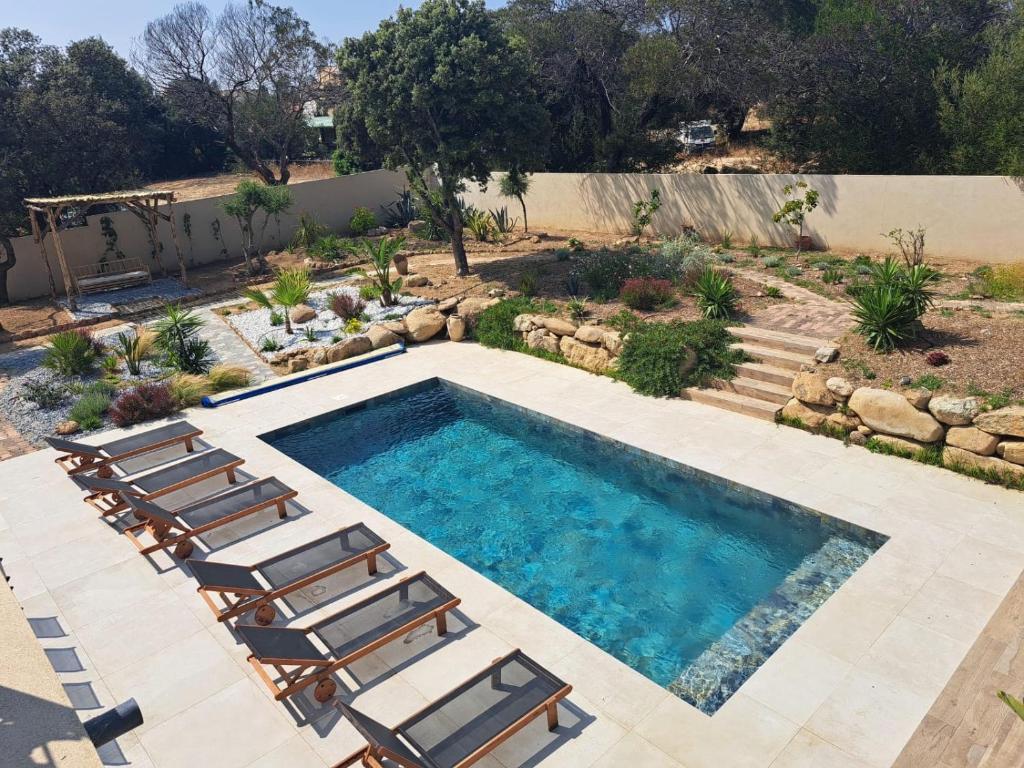 - une piscine avec des chaises longues à côté d'une cour dans l'établissement Residence I Pozzi, à Palasca