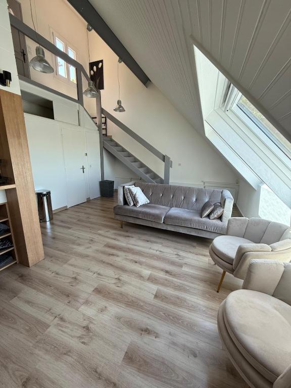 a living room with a couch and a staircase at Pretty little house Jolie petite maison in Rueil-Malmaison