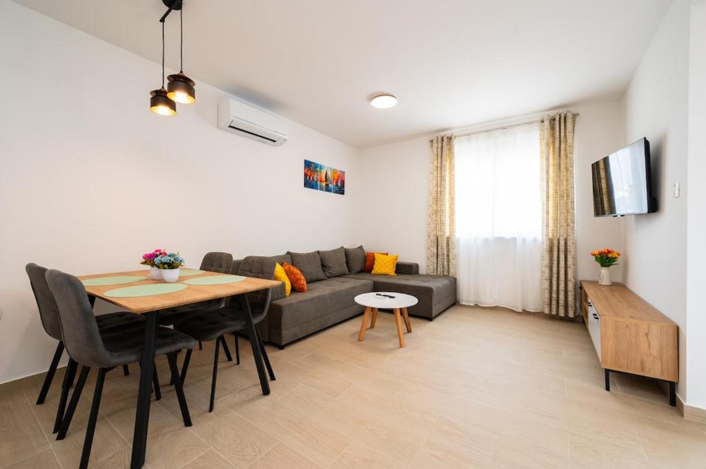 a living room with a gray couch and a table at ColorsVibe Apartment in Trogir