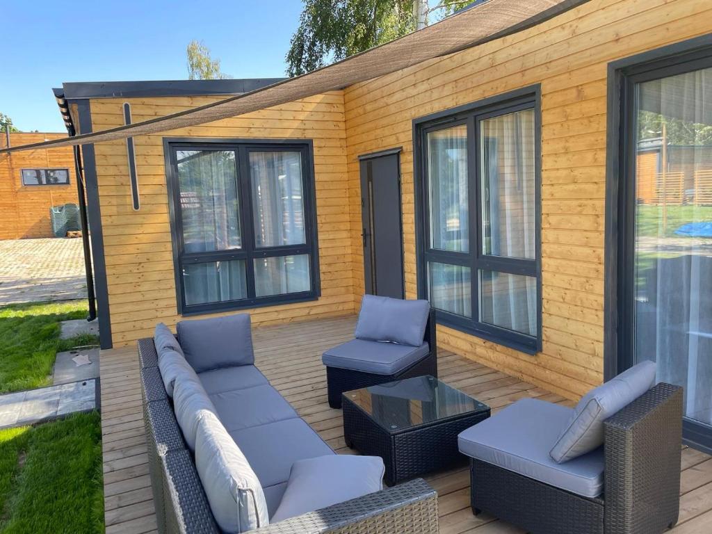 eine Terrasse mit einem Sofa, 2 Stühlen und einem Tisch in der Unterkunft Rajski Hel in Hel
