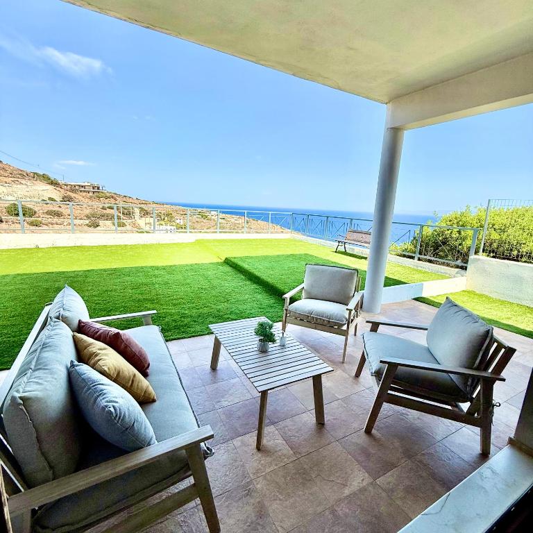 a living room with a couch and a table and chairs at Villa Kalli - Porto Ennia in Vromopoúsi