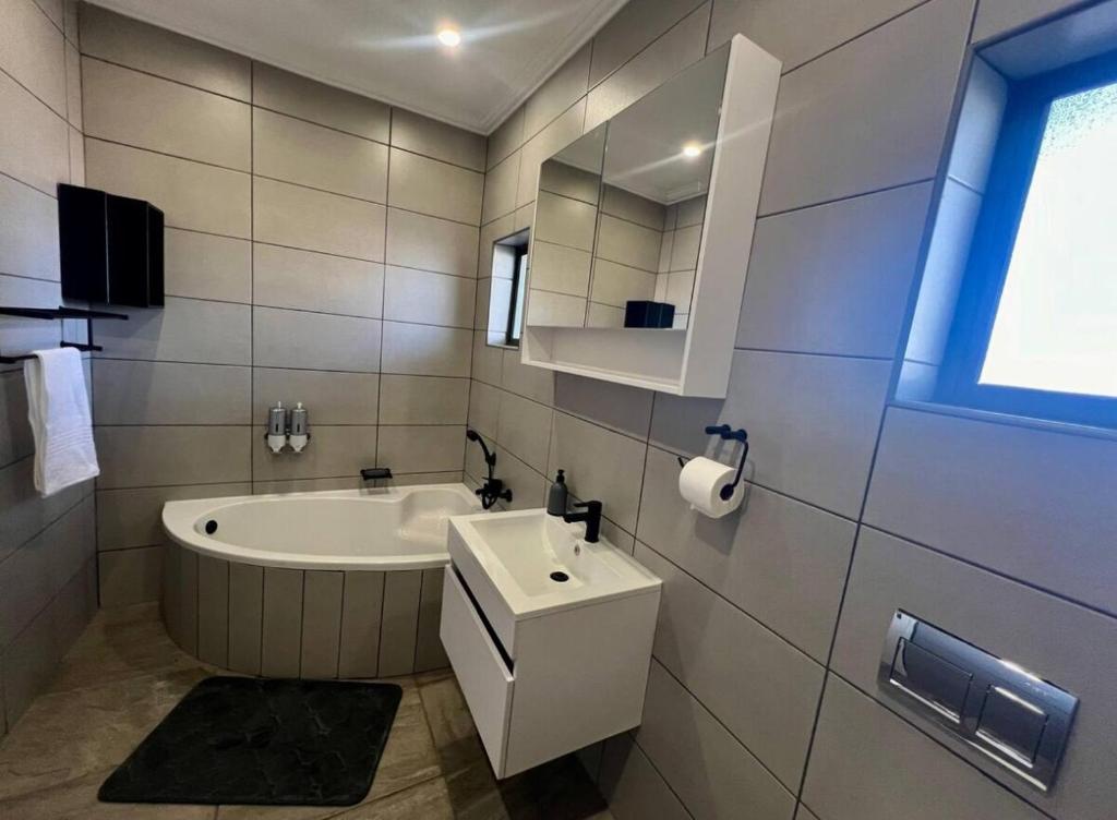 a white bathroom with a tub and a sink at Antelope Farm Events in Pretoria