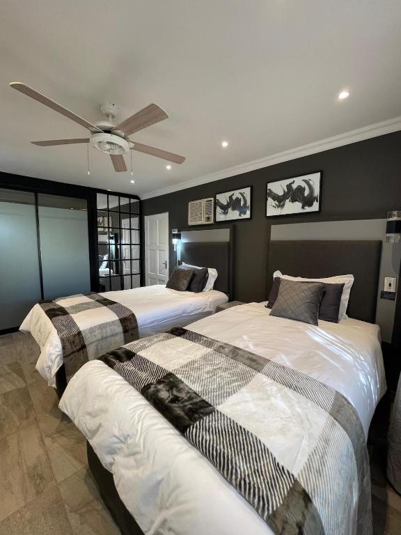 a bedroom with two beds and a ceiling fan at Antelope Farm Events in Pretoria