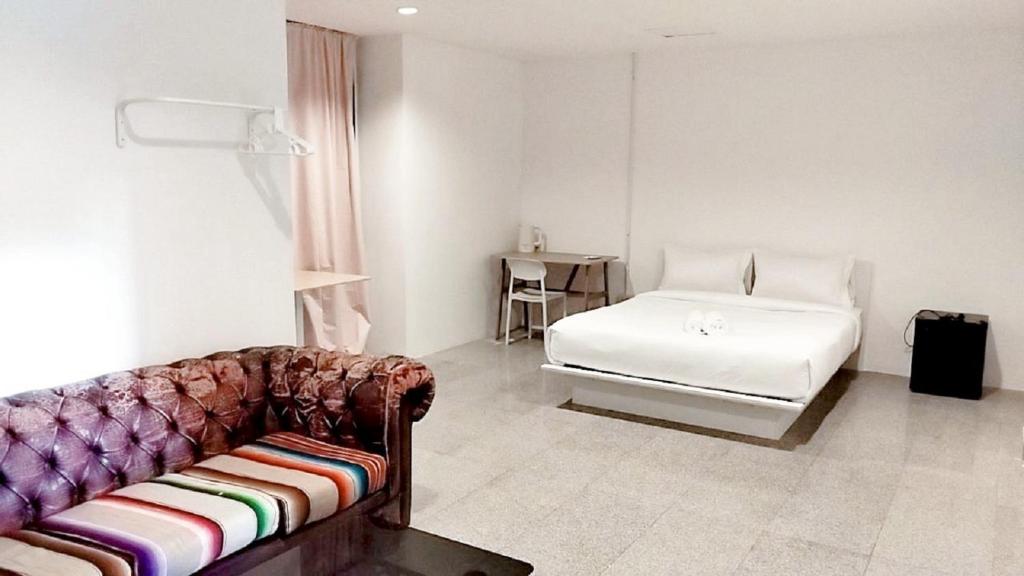 a living room with a couch and a bed at X Mitr INN Sukhumvit 2 BTS Nana มิตร อินน์ สุขุมวิท 2 บีทีเอสนานา in Bangkok