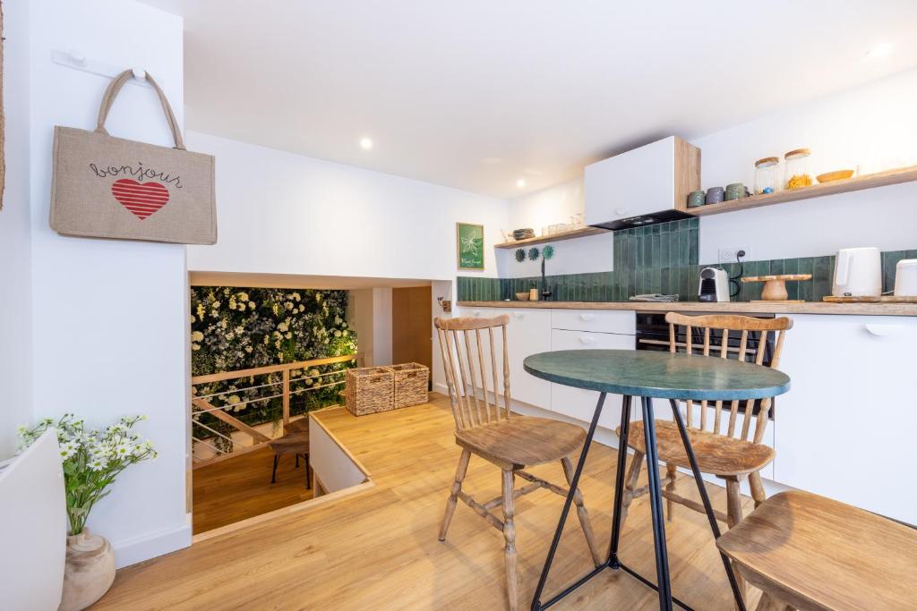 une cuisine et une salle à manger avec une table et des chaises dans l'établissement La P'tite Barque des Remparts Plage, à Saint-Malo