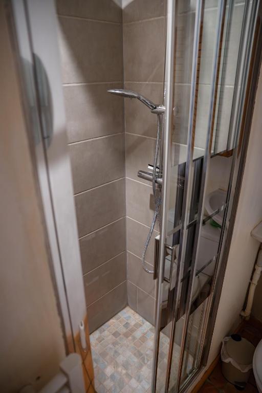 a shower with a glass door in a bathroom at La Parenthèse Campagnarde in Richarville