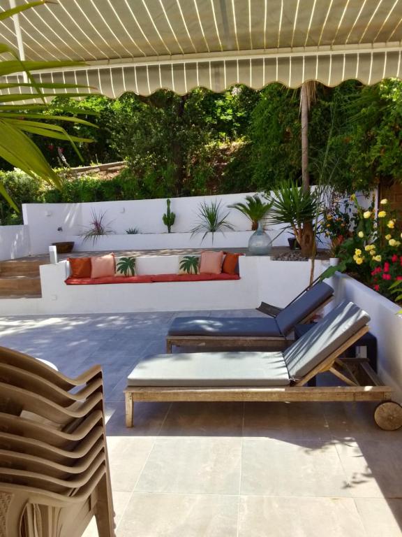 une terrasse avec un canapé et une chaise dans l'établissement Maison Almanarre, à Hyères