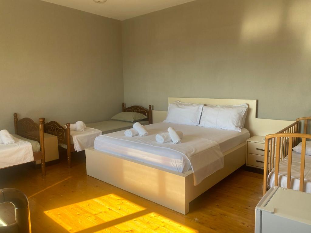 a bedroom with a large bed and two twin beds at Meti guest house in Krujë