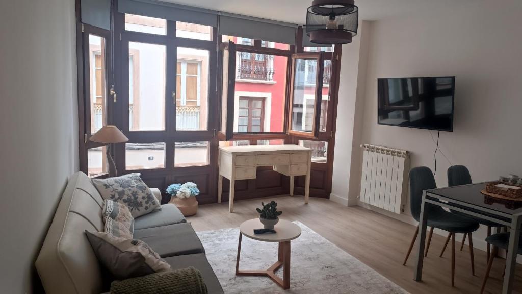 Una sala de estar con un sofá, una mesa y un escritorio. en Apartamento Galería Cine Colón, en Ribadeo