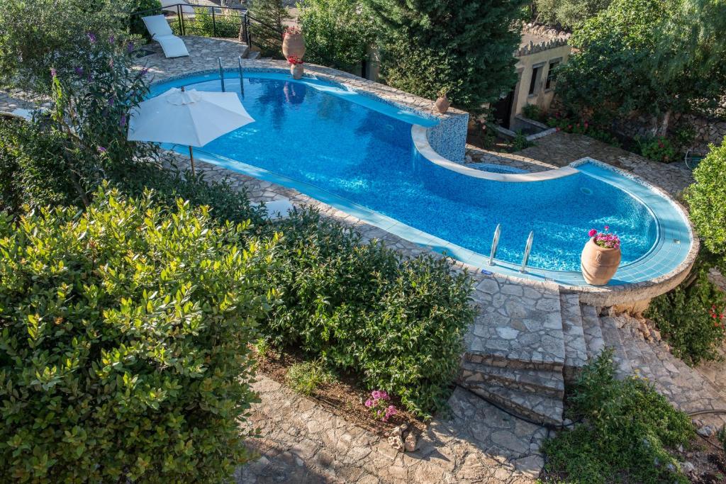 an overhead view of a swimming pool with an umbrella at Antheia Houses in Vamos