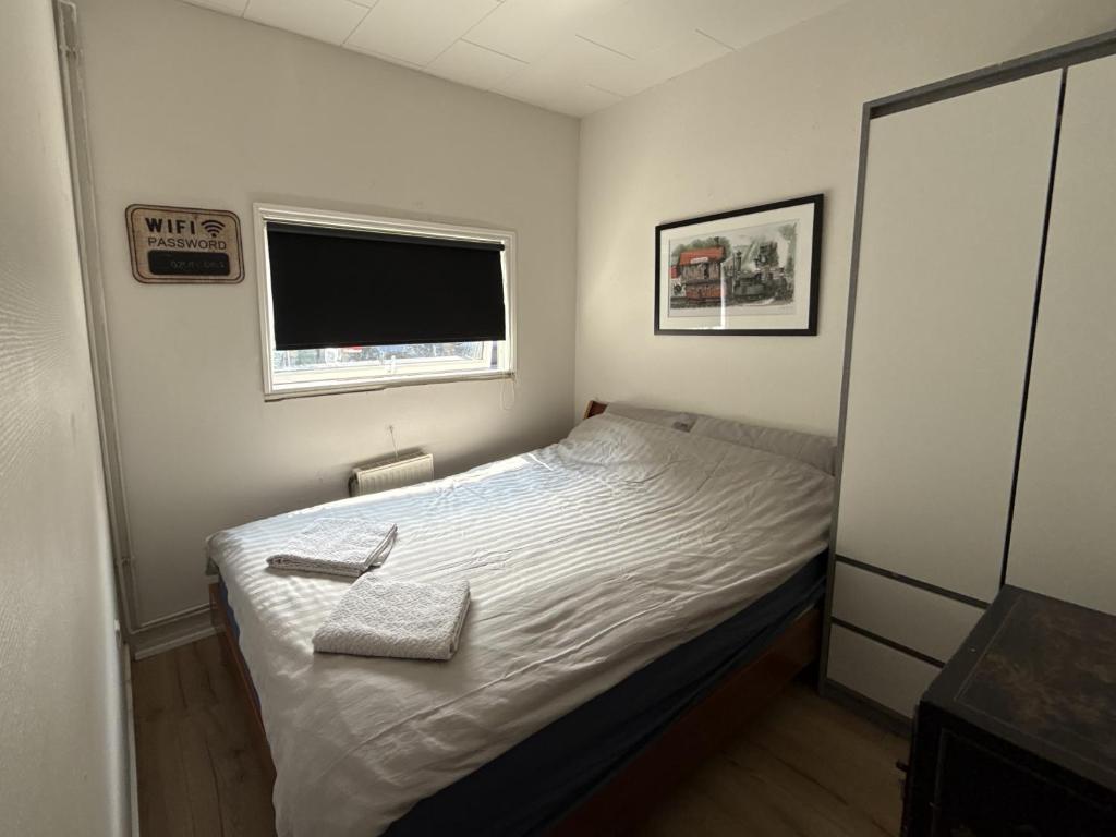 a small bedroom with a bed and a window at Cozy Room in the heart of Rødby! 5km from Femern & Puttgarden! in Rødby