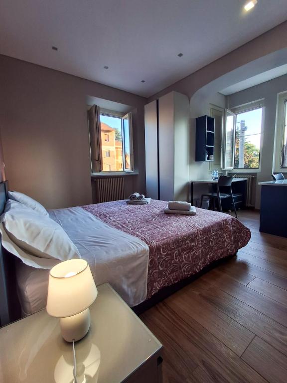 Un dormitorio con una cama y una mesa con una lámpara. en Casa del corso, en Collegno