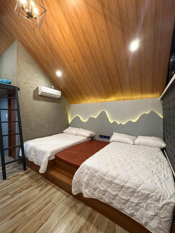 a bedroom with two beds in a room with wooden ceilings at Eunice Cabins in Manolo Fortich