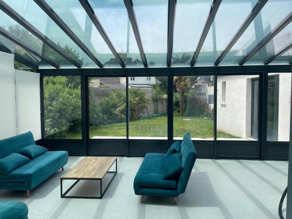 Una sala de estar con dos sofás azules y una mesa. en Dinard centre, en Dinard
