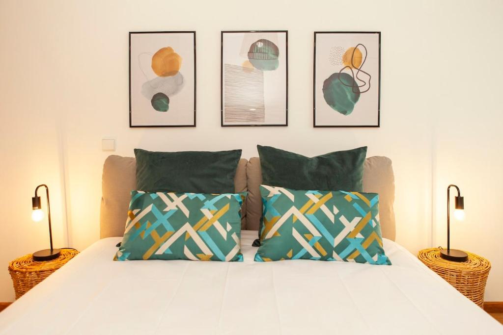 a bedroom with a bed with four pictures on the wall at Sea waves - Olhão in Olhão