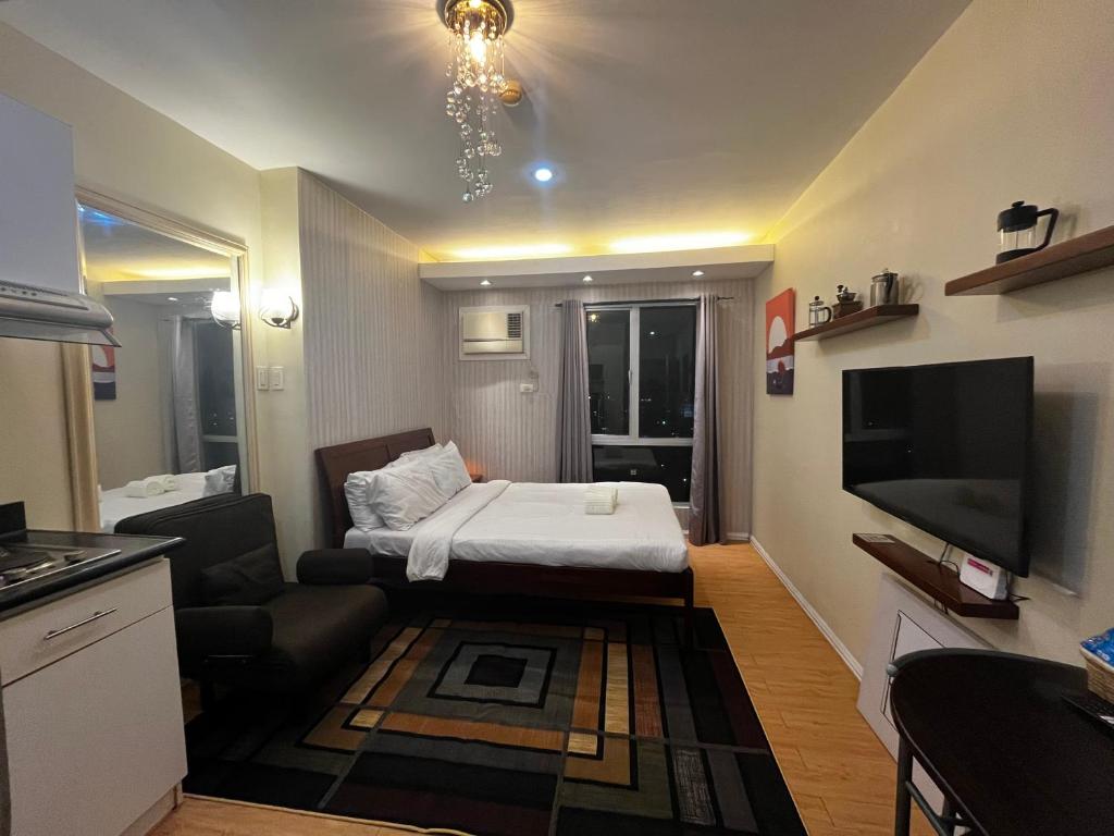 a small living room with a bed and a television at Studio unit inside IT Park Wifi & Netflix in Cebu City
