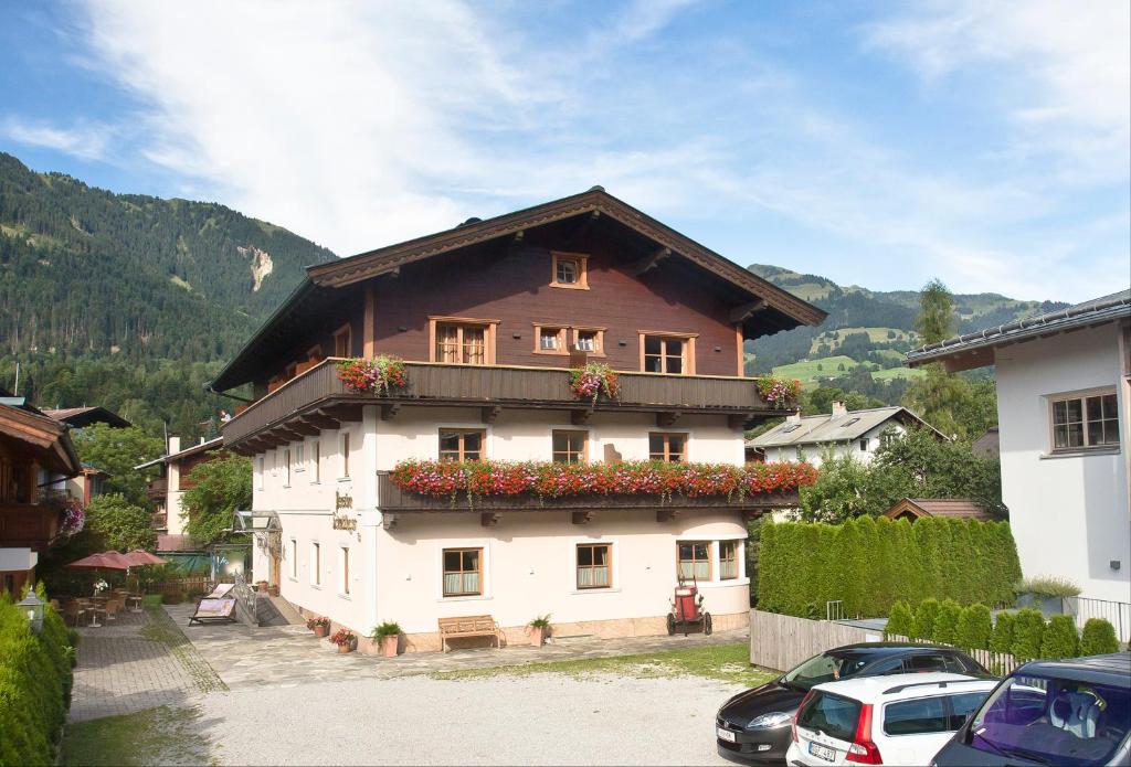Una casa grande con flores al costado. en Pension Schmidinger en Kitzbühel