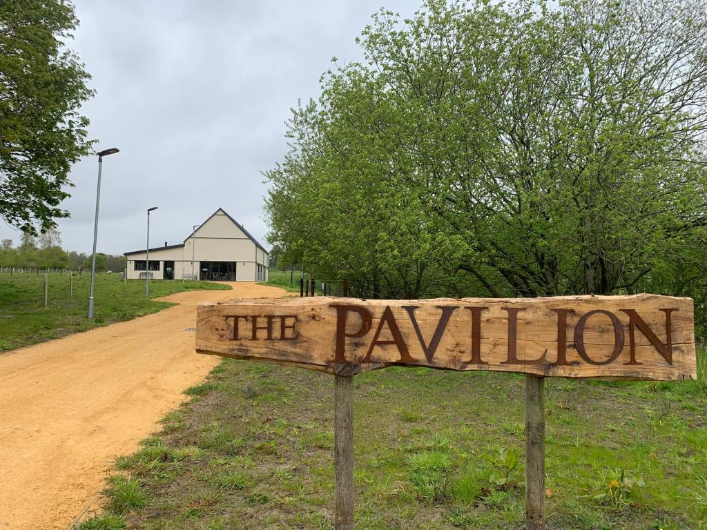 a wooden sign that reads the pavilion on a dirt road at 2 Beechwood at Thoulstone Park in Corsley