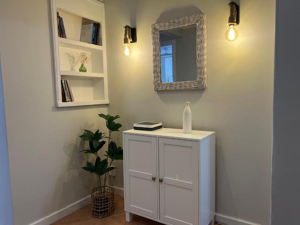 a room with a white cabinet and a mirror at Garden Beach Apartament in Boiro