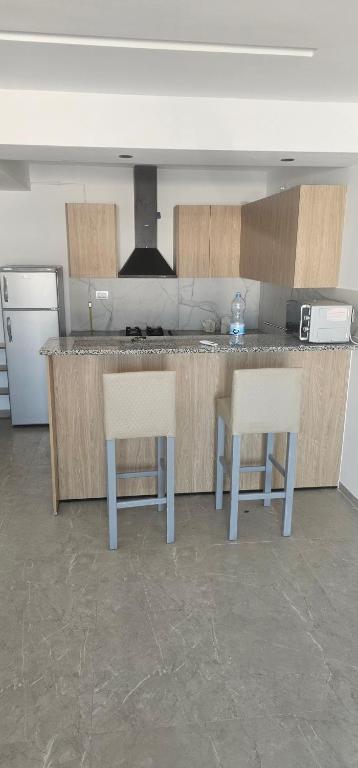 a kitchen with two chairs and a counter top at two-bedroom apartment with a living room, kitchen and balcony in Monastir