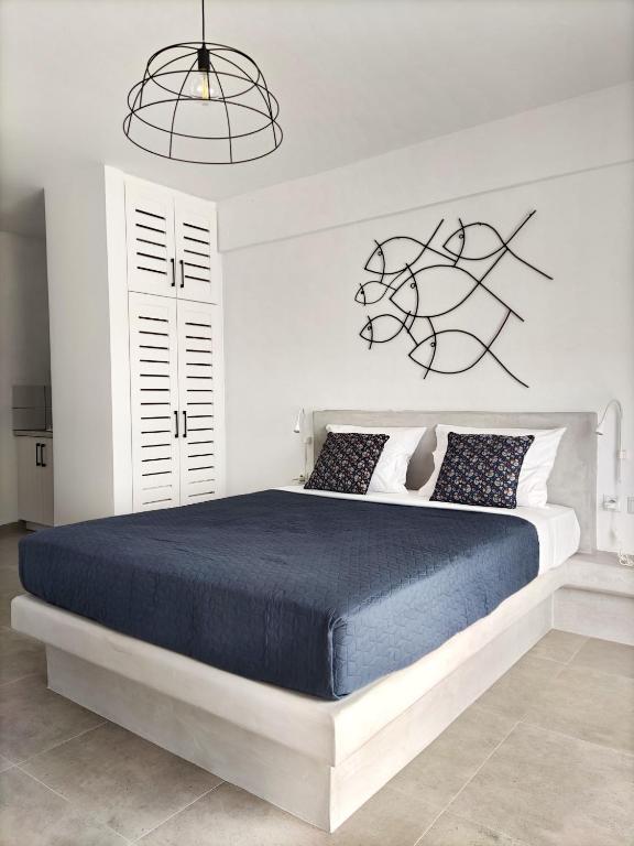 a bedroom with a large bed with a blue blanket at EmMi Houses in Nafplio