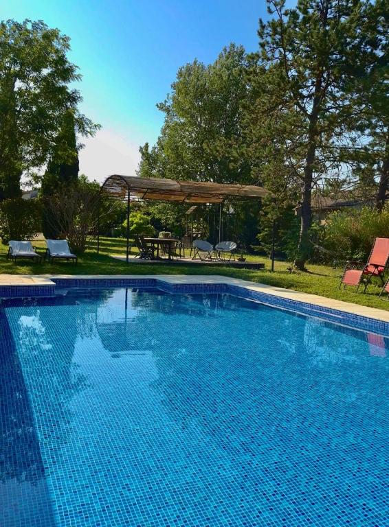 une grande piscine bleue avec un gazebo dans l'établissement Le Provencou, à Tulette
