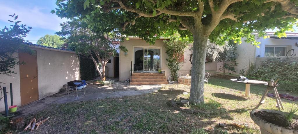 a house with a tree in the yard at Chez ROGER in Oraison