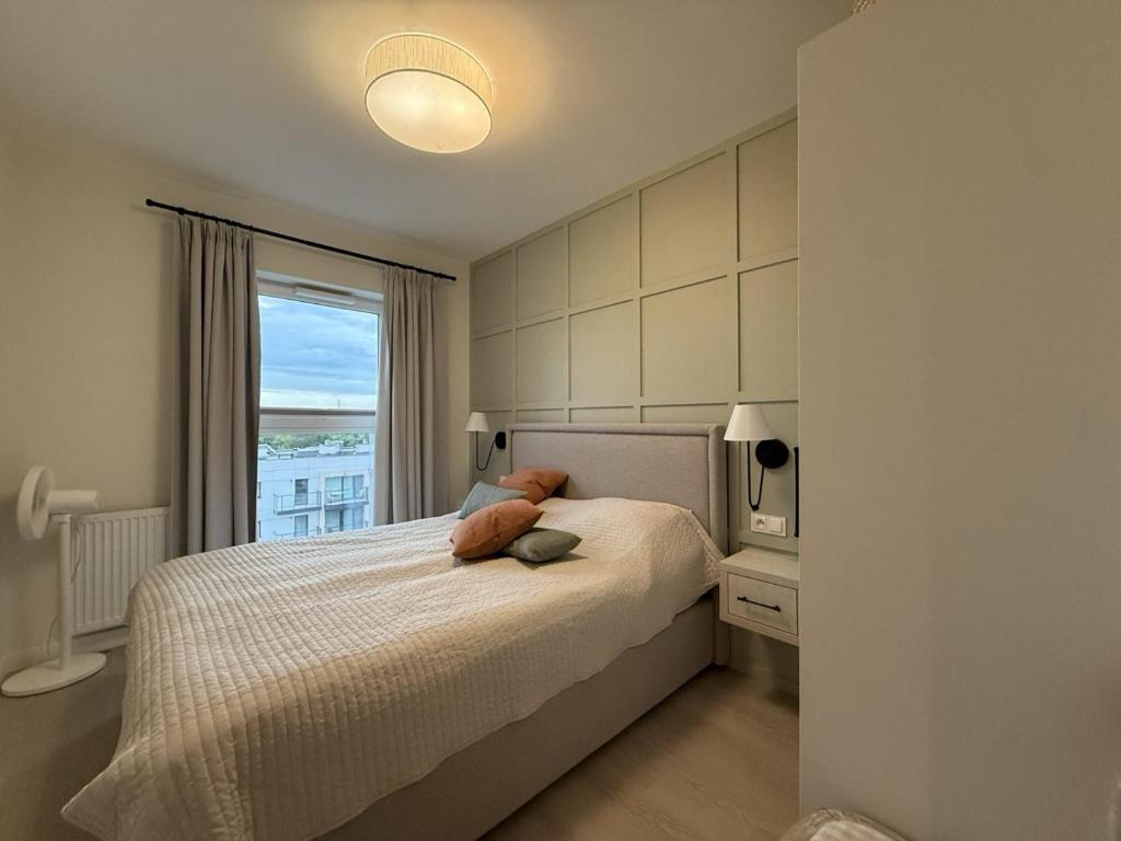 a bedroom with a bed with a large window at Cosmo Apartments Baltic Sea in Gdańsk