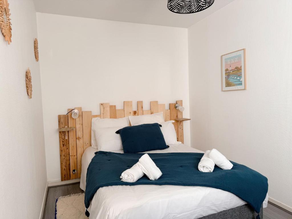 une chambre avec un grand lit avec deux oreillers dessus dans l'établissement Appartement tout confort avec parking, Aquarium, à La Rochelle