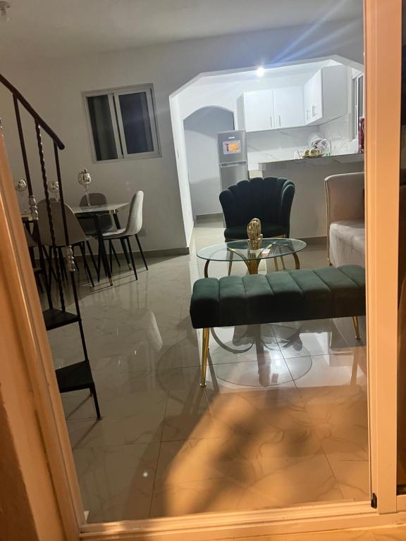 ein Wohnzimmer mit einem Stuhl und einem Tisch in der Unterkunft Comodo y acogedor apartamento en Los Mameyes in Los Tres Ojos de Agua