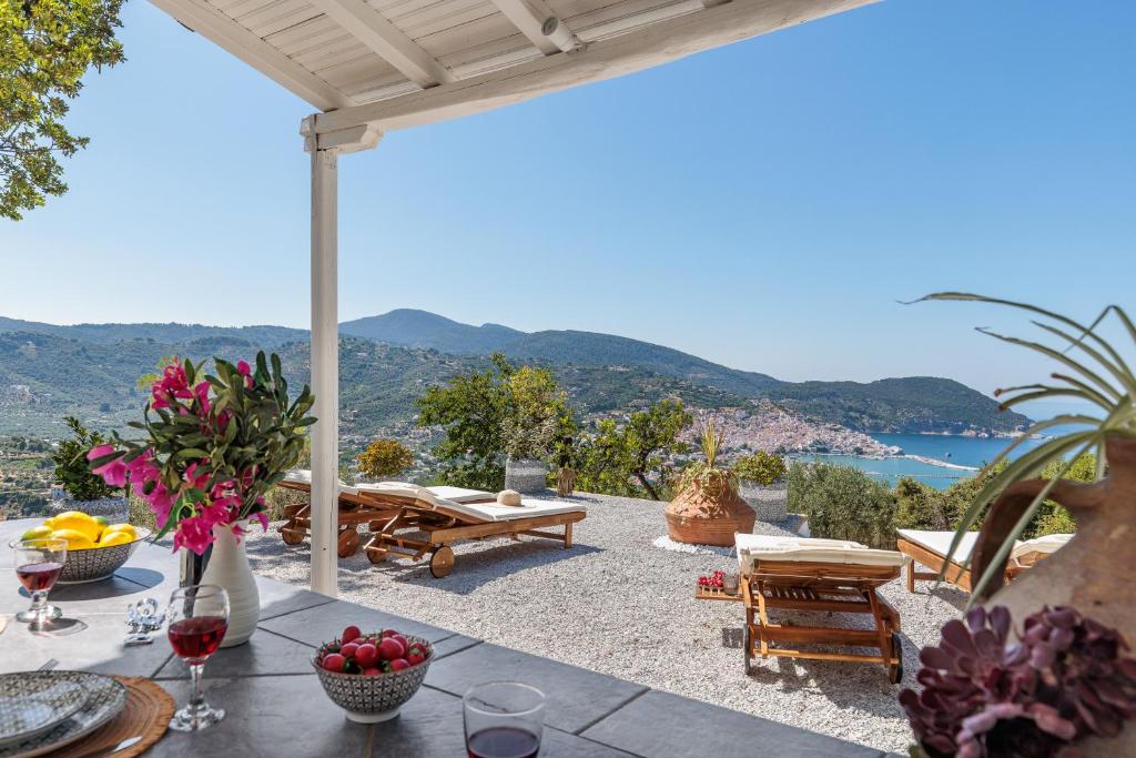 a patio with a table with a view of the ocean at Bleu & Vert in Skopelos Town