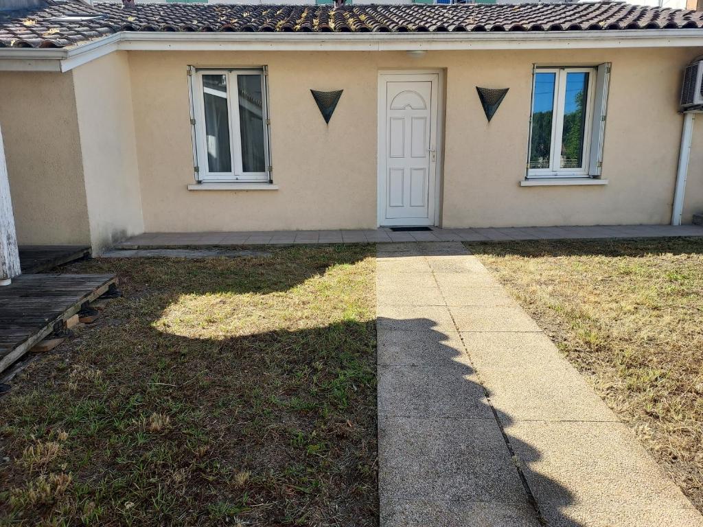 ein Haus mit einer weißen Tür und einem Hof in der Unterkunft petite maison lavardac in Lavardac