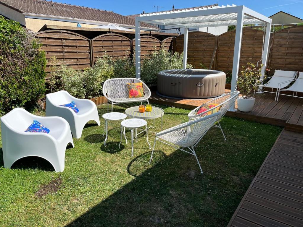 a backyard with chairs and a table and a grill at Maison familiale 100m2 in Witry-lès-Reims