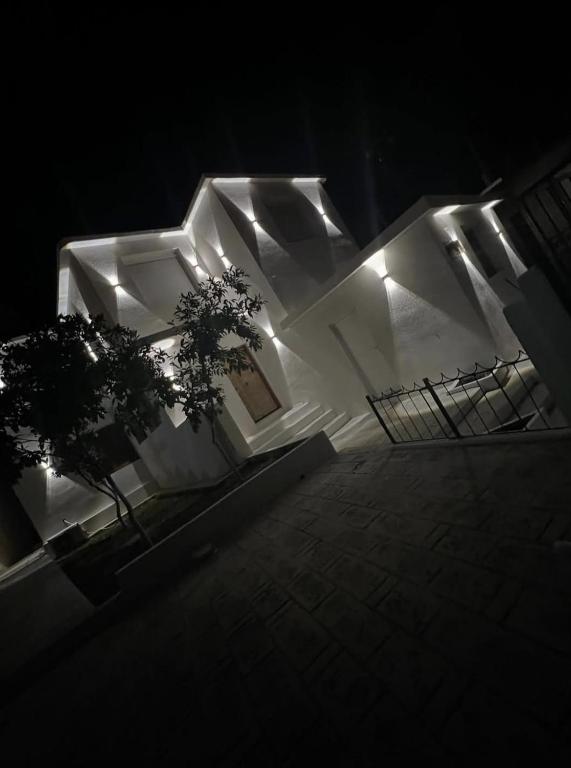 a white building with lights on it at night at Vila Oron in Vlorë