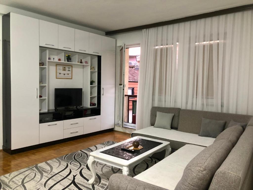 a living room with a couch and a tv at Orion apartment in Pristina