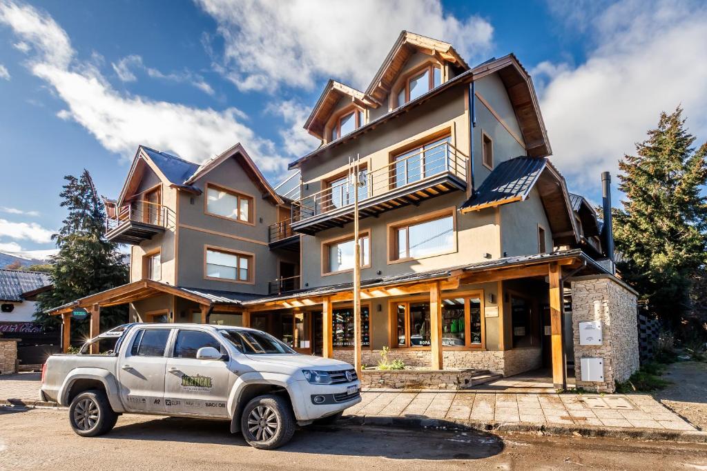 un camión blanco estacionado frente a una casa en CIERVO - Departamento céntrico, en Villa La Angostura