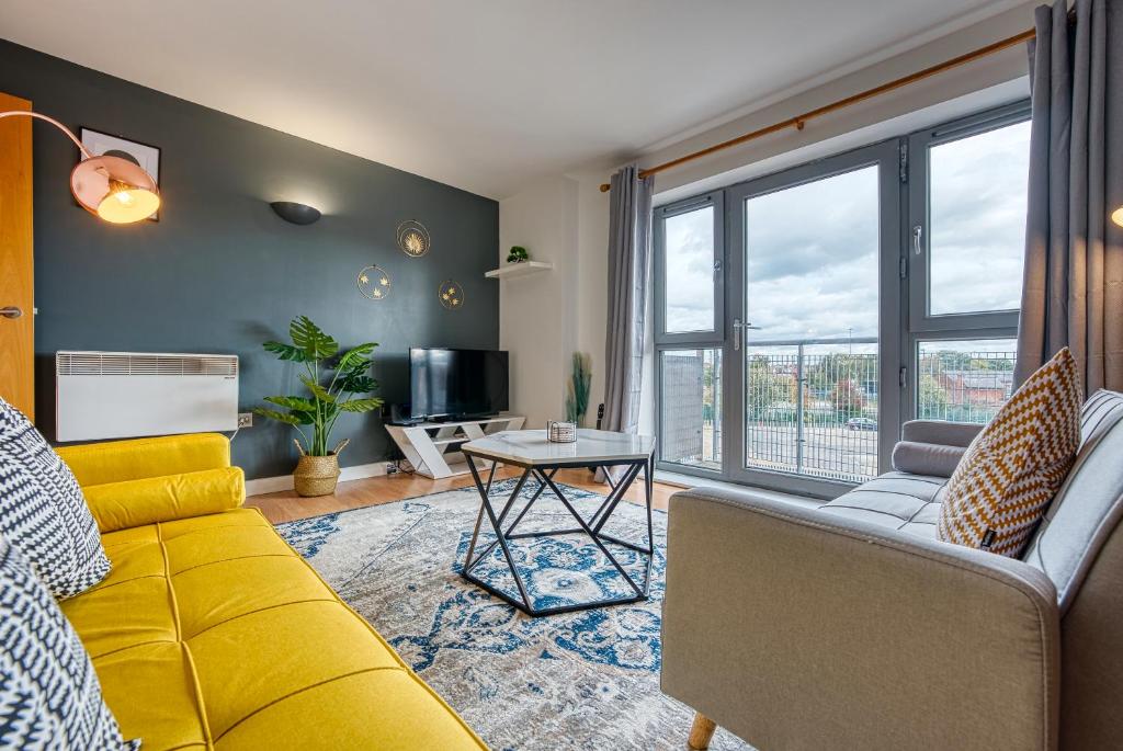 un soggiorno con un divano giallo e un tavolo di The Contractor City Spot with Parking a Derby