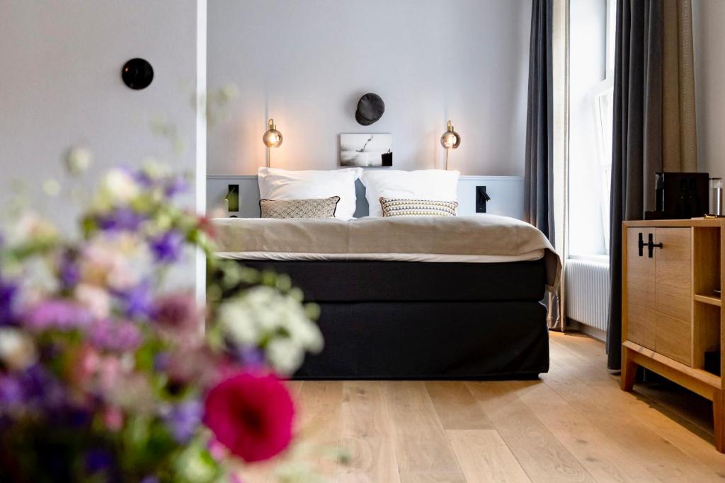 a bedroom with a bed and flowers in the foreground at Boutiquehotel Petuh am Hafen - adults only in Flensburg
