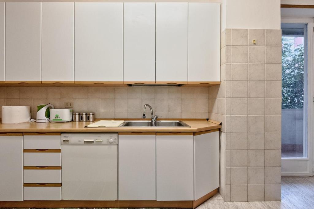 a kitchen with white cabinets and a sink at Leonardo apartment in Venice