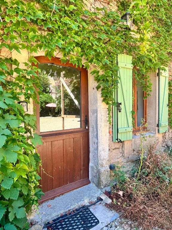 a house with a wooden door and a window at Logement entier dans les Corbières in Coustouge