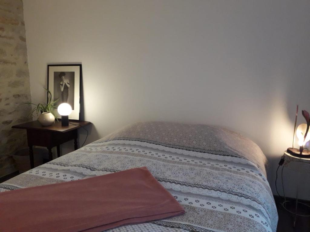 Un dormitorio con una cama y una mesa con dos lámparas. en COSY CHIC - STAYHOME - Appart 2, en Quimper
