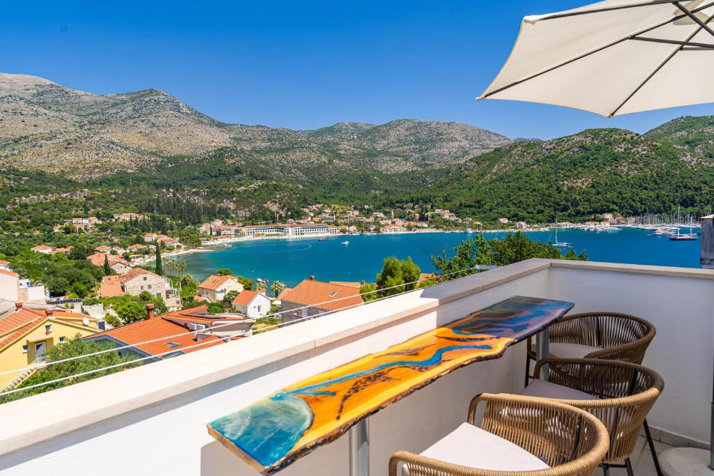 Un balcón con sillas y vista al agua. en RITA - Charming 2-Bedroom Apartment with sea view, Slano, en Slano